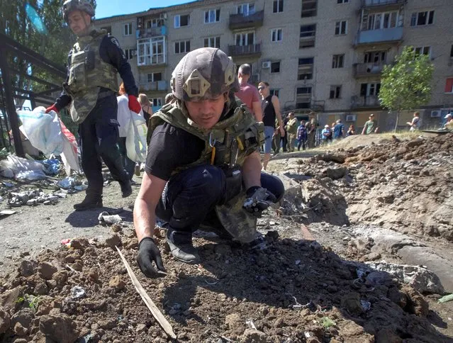 A police expert works near an apartment building destroyed in a military strike, amid Russia's invasion of Ukraine, in Kurakhove, Ukraine on June 7, 2022. (Photo by Anna Kudriavtseva/Reuters)