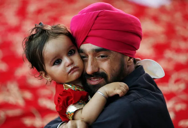 An Afghan Sikh holds his child inside a Gurudwara, or a Sikh temple, during a religious ceremony in Kabul, Afghanistan June 8, 2016. (Photo by Mohammad Ismail/Reuters)