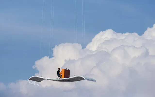 German pianist Stefan Aaron plays an orange piano on a “flying carpet” platform suspended from a helicopter, over the Munich airport July 23, 2014. The concert is the fourth station of the “Orange Piano Tour”, which brings the artist to places around the world. (Photo by Lukas Barth/Reuters)