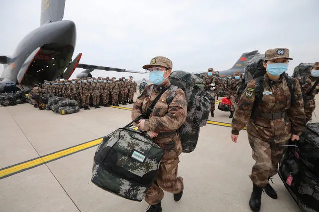 Military medics arrive at Tianhe International Airport in Wuhan, central China's Hubei Province, February 13, 2020. Ordered by the Central Military Commission, 11 transport aircraft of the People's Liberation Army Air Force Thursday sent medics and supplies provided by the armed forces to virus-hit Wuhan, capital of Hubei Province. This was the first time for China's domestically developed large transport aircraft Y-20 to take part in non-military action. It was also the first time for the Air Force to send large and medium transport aircraft on active service to carry out urgent air transport tasks on a large scale. (Photo by Reuters/China Stringer Network)