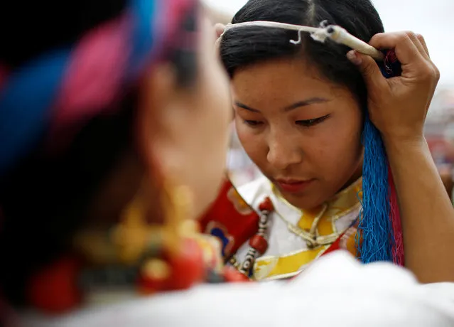 A Tibetan girl gets ready for a function organized to mark the birthday celebration of Dalai Lama in Kathmandu, Nepal, July 6, 2016. (Photo by Navesh Chitrakar/Reuters)