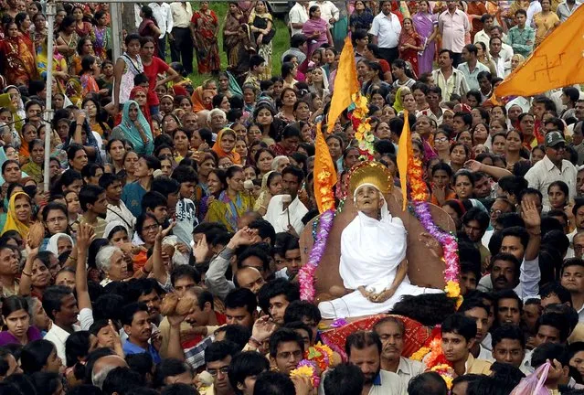 Members of the Jain community march outside the Digambar Jain temple with the body of Ajaymati Mataji, who is believed to have died after performing Sallekhena,  or the holy rite of fasting to death in Bhopal, India, on July 26, 2012. Supporters of this salvation ritual believe that Sallekhena cannot be considered suicide, but rather something one does with full knowledge and intent. (Photo by Associated Press)