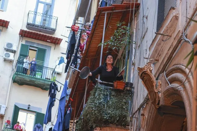 Women plays “music” with pots in Naples, Italy on March 13, 2020, during a flash mob to promote remote socializing through music when everyone is indoors in downtown after a Government Decree declaring all of Italy a protected area to combat COVID-19 – coronavirus infection, closing schools and public offices until April 3. (Photo by IPA/Backgrid UK)