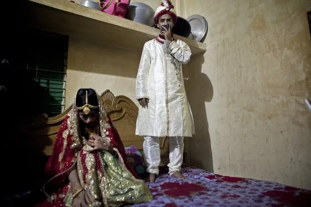 Mohammad Hasamur Rahman, 32, stands on a bed above his new bride, 15-year-old Nasoin Akhter, August 20, 2015, in Manikganj, Bangladesh. (Photo by Allison Joyce/Getty Images)