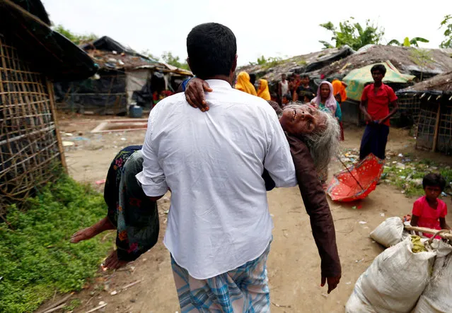 A man carries a Rohingya refugee woman from the shore after she crossed the Bangladesh-Myanmar border by boat through the Bay of Bengal in Teknaf, Bangladesh September 7, 2017. (Photo by Danish Siddiqui/Reuters)