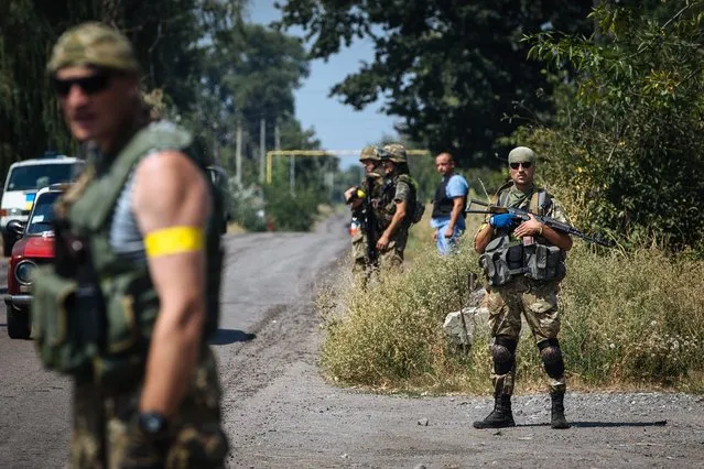 Ukrainian soldiers of the “Donbass” battalion stand guard during an anti-terrorist operation against militants, in Maryinka town, near of Donetsk, Ukraine, 12 August 2014. Ukrainian government forces have narrowed the ring around Luhansk and the other rebel stronghold in Donetsk. Fighting in the neighbouring Donetsk region continued unabated. (Photo by Roman Pilipey/EPA)