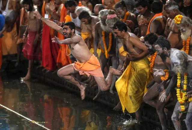 Sadhus, or Hindu holy men, jump in a holy pond during the first Shahi Snan (grand bath) at Kumbh Mela, or Pitcher Festival, in Trimbakeshwar, India, August 29, 2015. (Photo by Shailesh Andrade/Reuters)