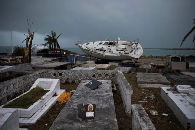 A sailing boat is beached in the cemetery of Marigot, on September 9, 2017 in Saint- Martin island devastated by Irma hurricane. Officials on the island of Guadeloupe, where French aid efforts are being coordinated, suspended boat crossings to the hardest- hit territories of St. Martin and St. Barts where 11 people have died. Two days after Hurricane Irma swept over the eastern Caribbean, killing at least 17 people and devastating thousands of homes, some islands braced for a second battering from Hurricane Jose this weekend. (Photo by Martin Bureau/AFP Photo)