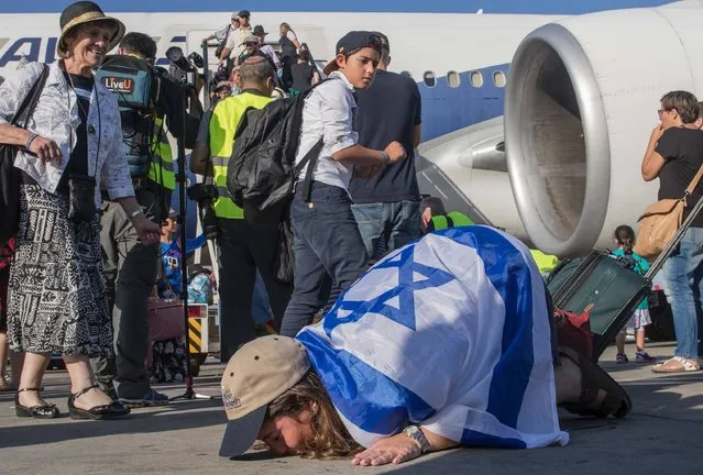 A newly arrived Jewish immigrant coming from North America kisses the tarmac after disembarking a plane upon her arrival at the Ben Gurion International Airport near Tel Aviv on July 19, 2016. According to Nefesh B'Nefesh, the Israeli Immigration Authority, some 218 Jews from North America arrived in Israel on July 19, 2016. (Photo by Jack Guez/AFP Photo)