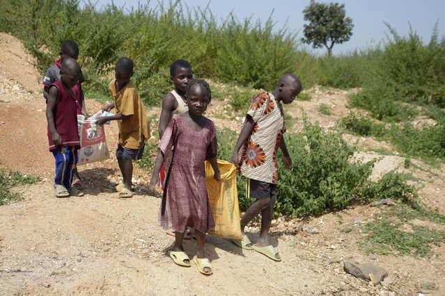 Juliet Samaniya, 6, carries a bag of lithium with other children at an illegal mining site in Paseli, Nigeria, November 5, 2024. (Photo by Sunday Alamba/AP Photo)
