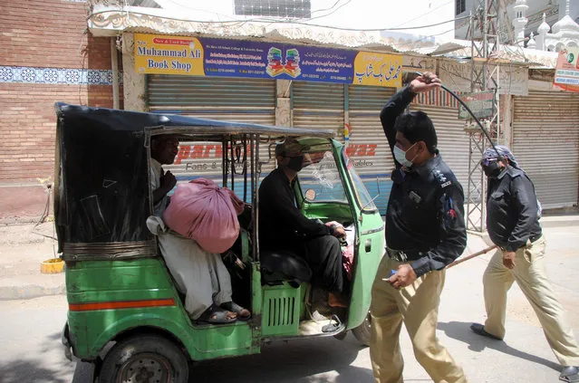 Police officers restrict a rickshaw driver defying the nation-wide lockdown to curb the spread of the coronavirus in Hyderabad, Pakistan, Friday, March, 3, 2020. Some mosques were allowed to remain open in Pakistan on Friday, the Muslim sabbath when adherents gather for weekly prayers, even as the coronavirus pandemic spread and much of the country had shut down. (Photo by Pervez Masih/AP Photo)