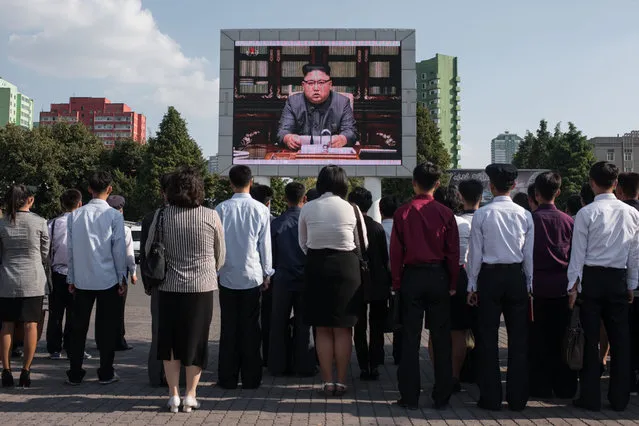 Spectators listen to a television news brodcast of a statment by North Korean leader Kim Jong-Un, before a public television screen outside the central railway station in Pyongyang on September 22, 2017. US President Donald Trump is “mentally deranged” and will “pay dearly” for his threat to destroy North Korea, Kim Jong-Un said on September 22, as his foreign minister hinted the regime may explode a hydrogen bomb over the Pacific Ocean. (Photo by Ed Jones/AFP Photo)
