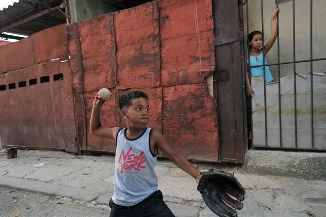 Kevin Kindelan, 8, practices baseball in front of his house in Havana, Cuba on July 15, 2022. Success in baseball, Cuba's national past time and a favorite pursuit of former Cuban leader Fidel Castro, is increasingly measured beyond its borders. That mirrors a broader exodus of Cubans from the stagnating communist-run island racked by social and economic crisis. (Photo by Alexandre Meneghini/Reuters)