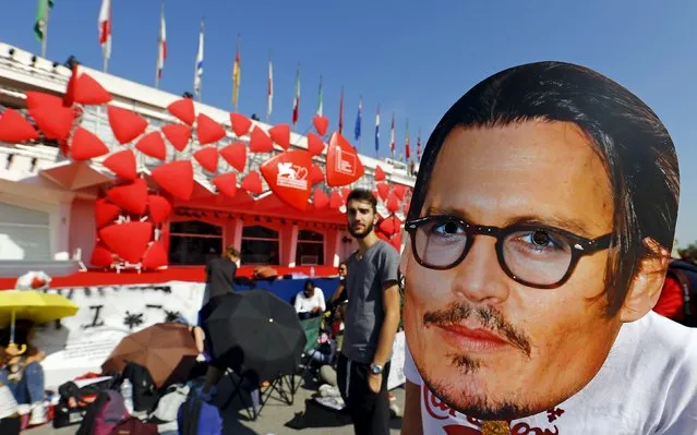 A girl wears a mask of actor Johnny Depp in front of the entrance of the venue of the 72nd Venice Film Festival, northern Italy September 4, 2015. Depp will attend the red carpet for the movie “Black Mass”. (Photo by Stefano Rellandini/Reuters)