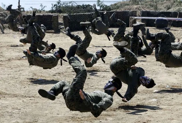 South Korean army special forces members demonstrate their martial art skills as part of a reenactment event during Naktong River Battle re-enactment in Waegwan, South Korea, Thursday, September 10, 2015. South Korean Defense Ministry re-enacted one of the important battles as part of commemoration events for the 65th anniversary of the Korean War. (Photo by Ahn Young-joon/AP Photo)