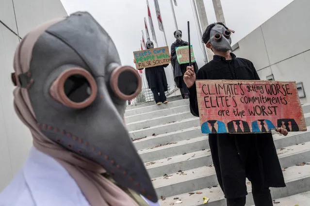 Environmental activists wearing masks carry placards during a Global Climate Strike rally in Jakarta, Indonesia on September 23, 2022. (Photo by Aprillio Akbar/Antara Foto via Reuters)