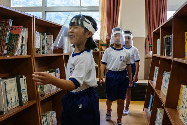 Students wearing face shields visit the library in Kinugawa Elementary School in Nikko, Tochigi Prefecture, Japan on June 5, 2020. (Photo by Philip Fong/AFP Photo)