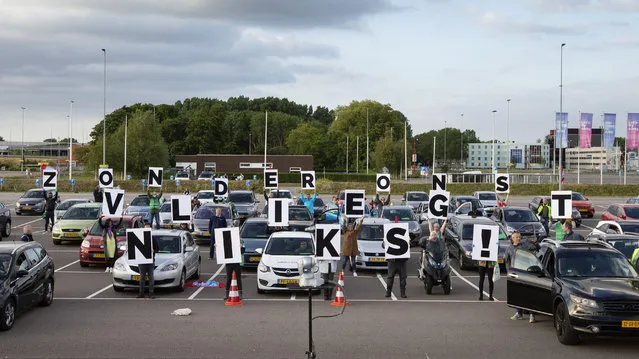 Schiphol Airport employees hold placards to form the words “Without us nothing flies” during a drive-in rally of FNV Schiphol to call on management to increase employee safety measures amid the outbreak of the COVID-19 disease (novel coronavirus), at Schiphol airport, Badhoevedorp, on June 9, 2020. (Photo by Pieter Stam de Jonge/ANP/AFP Photo)