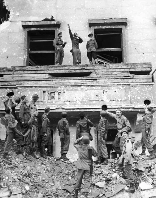 The final victory over Nazi Germany achieved, soldiers and allies of the British, American and Russian armies mimic and mock Adolf Hitler and his ideas on Hitler's famous balcony at the Chancellery in conquered Berlin, 1945. (Photo by Fred Ramage)