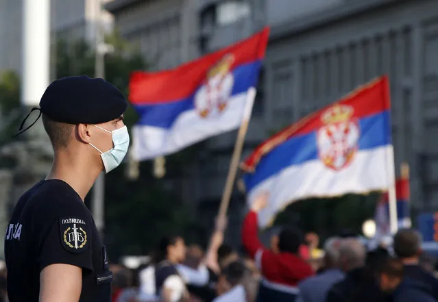 A police officer, wearing a mask to protect against coronavirus, guards the Serbian parliament building during a protest against President Aleksandar Vucic and his government, in Belgrade, Serbia, Saturday, June 20, 2020. Serbia is holding a parliamentary vote this weekend that takes place amid concerns over continuing spread of the new coronavirus and deep political divisions in the Balkan country. The ruling populist of President Aleksandar Vucic are expected to cement their grip on power at Sunday's balloting, facing practically no challenge from the opposition parties despite Serbia's plummeting democracy record and mounting allegations of corruption. (Photo by Darko Vojinovic/AP Photo)