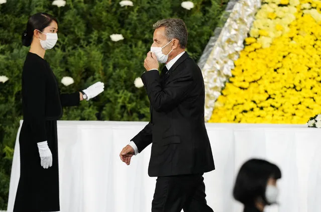 France's former president Nicolas Sarkozy walks off the stage after offering flowers during the state funeral for Japan's former prime minister Shinzo Abe in the Nippon Budokan in Tokyo on September 27, 2022. (Photo by Franck Robichon/Pool via AFP Photo)