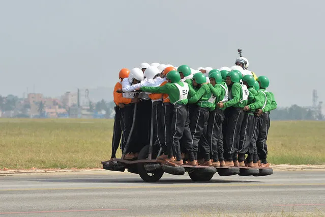 Members of the Tornadoes motorcycle display team of the Army Service Corps (ASC) on the final run for the World Record for carrying 58 men on a single 500 cc motorcycle in Bangalore on November 19, 2017. The Tornadoes team which presently holds a total of 19 World Records achieved the feat on the two wheeler by traversing a distance in excess of kilometer with 58 men on it. (Photo by Manjunath Kiran/AFP Photo)