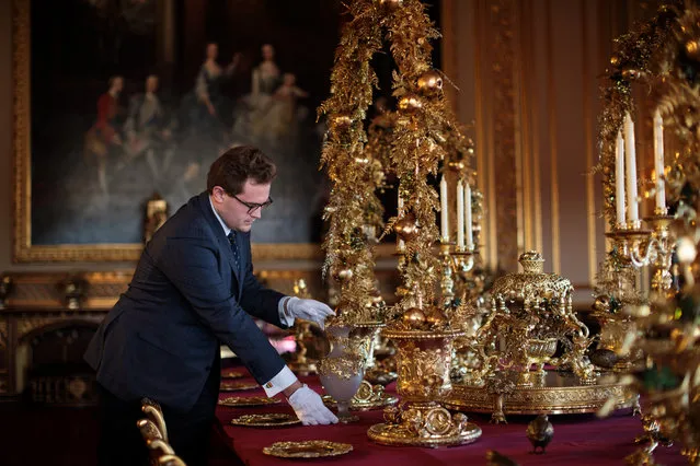 An employee poses by the table in the State Dining Room which has been decorated for the Christmas period with silver-gilt pieces from the Grand Service on November 23, 2017 in Windsor Castle, England. The Windsor Castle State Apartments are used by members of the Royal Family for hosting and events. Queen Elizabeth II resides at Windsor Castle most weekends and over the easter period and it is the oldest and largest inhabited castle in the world. (Photo by Jack Taylor/Getty Images)