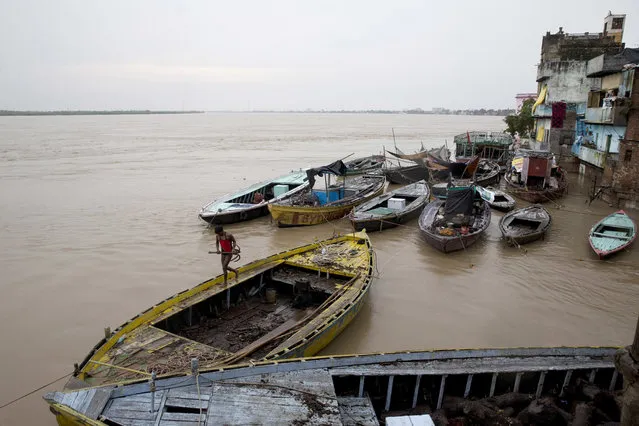 In this Friday, August 26, 2016 photo, boats are docked at the Manikarnika Ghat, submerged by the flood waters in Varanasi, India. (Photo by Tsering Topgyal/AP Photo)