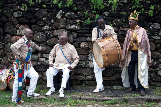 Revellers take a rest during the traditional Reinado de Nossa Senhora do Rosário e Santa Ifigênia (Reign of Our Lady of the Rosary and St Ifigenia) festival to honour Chico Rei, through the historic streets of Ouro Preto, Brazil, on January 14, 2024. According to tradition, Chico was the king of a tribe in Congo brought by the Portuguese as a slave and who managed to buy his freedom and that of other slaves to become “king” in Ouro Preto and, from then on, part of the Brazilian folklore. (Photo by Douglas Magno/AFP Photo)