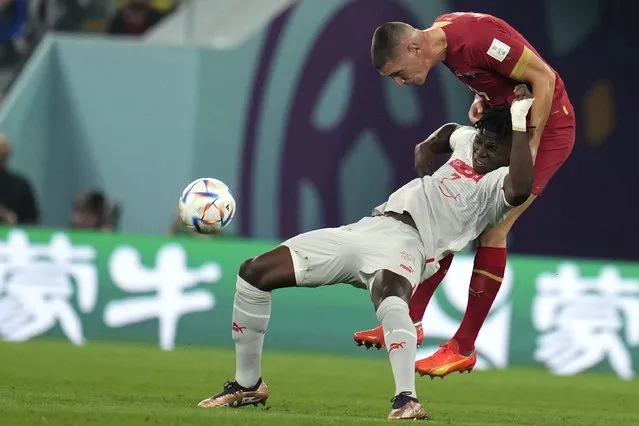 Serbia's Nikola Milenkovic, right, and Switzerland's Breel Embolo, challenge for the ball during the World Cup group G soccer match between Serbia and Switzerland, in Doha, Qatar, Qatar, Friday December 2, 2022. (Photo by Ricardo Mazalan/AP Photo)