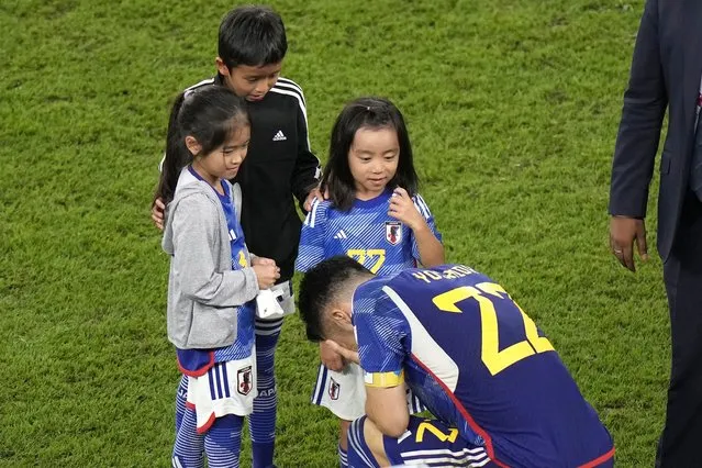 Japan's Maya Yoshida kneels in front of children after the World Cup round of 16 soccer match between Japan and Croatia at the Al Janoub Stadium in Al Wakrah, Qatar, Monday, December 5, 2022. (Photo by Luca Bruno/AP Photo)