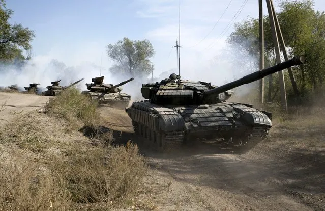 Members of the self-proclaimed Luhansk People's Republic (LNR) ride tanks as they withdraw them further from the frontline outside Luhansk, Ukraine, October 3, 2015. (Photo by Alexander Ermochenko/Reuters)