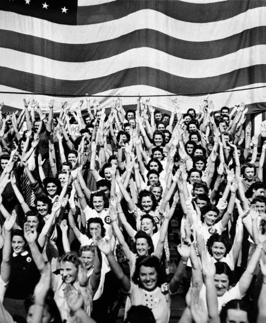 The Girl Defense Workers, Employees of the RCA Manufacturing Company, raise their arms in the sign of "V", the symbol for victory, during a calisthenics drill, October 6, 1941 in Camden to demonstrate how defense workers can keep fit. (Photo by AP Photo)