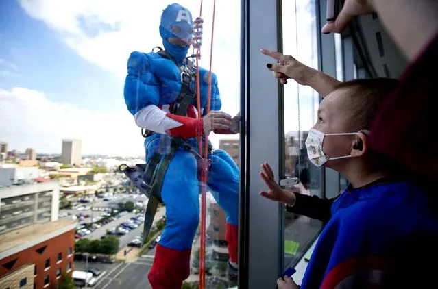 Landon Fox, 5, of Birmingham, looks up to see his favorite superhero, Captain America, a window washer dressed as a superhero at Benjamin Russell Hospital for Children, Wednesday, October 7, 2015, in Birmingham, Ala. (Photo by Brynn Anderson/AP Photo)