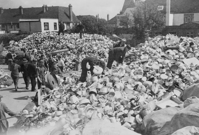 These huge piles of aluminum pots and pans were contributed by English housewives to be melted down into metal for British fighting planes. Workers sorting the material, July 29, 1940. The offerings were in response to Lord Beaverbrook's appeal to the women of England. (Photo by AP Photo)