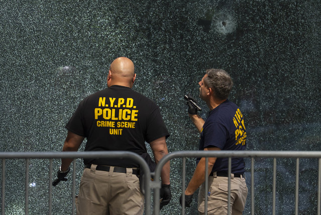 Members of the NYPD Crime Unit examine glass shattered by bullets at the scene of Monday's deadly shooting, Tuesday, July 29, 2025, in New York. (Photo by Yuki Iwamura/AP Photo)