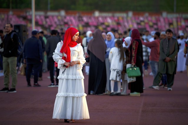 A young woman poses for a friend before the Eid al-Fitr prayers in Bucharest, Romania, Wednesday, April 10, 2024. Members of the Romanian Muslim community joined prayers at the Dinamo stadium in the Romanian capital, in the largest Muslim public gathering of the year. Eid al-Fitr marks the end of the holy fasting month of Ramadan. (Photo by Andreea Alexandru/AP Photo)