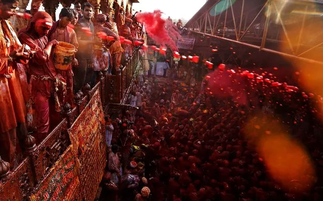 Men throw and spray colored water on men from the village of Nangaon before the procession for the Lathmar Holi festival in Barsana. (Photo by Kevin Frayer/Asasociated Press)