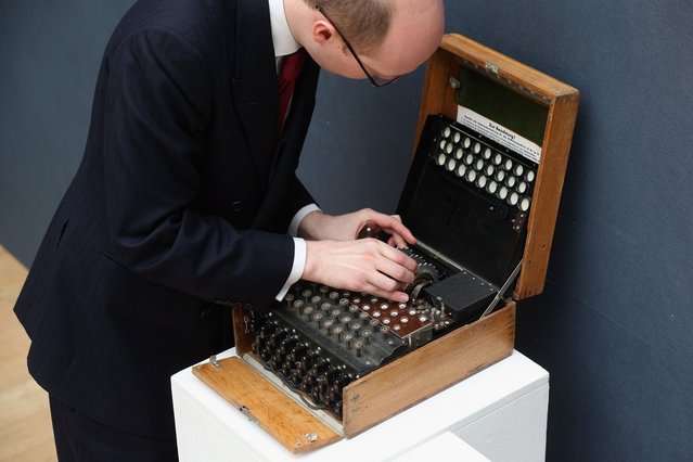 An employee at Christie's auction house examines an Enigma cipher machine on March 27, 2013 in London, England. The Enigma machine is expected to fetch 60,000 GBP when it features in Christie's “Travel, Science and Natural History” sale, which is to be held on April 24, 2013 in London.  (Photo by Oli Scarff)