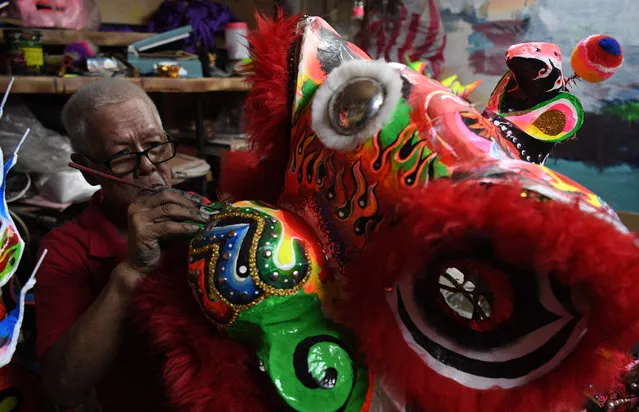 Filipino-Chinese artist Nicasio Madaraog paints one of his creations of a lion figure to be used in the Chinese traditional dance and performance for the Lunar New Year at his house in Chinatown district of Manila on January 18, 2023, ahead of the Lunar New Year of the Rabbit, which falls on January 22. (Photo by Ted Aljibe/AFP Photo)