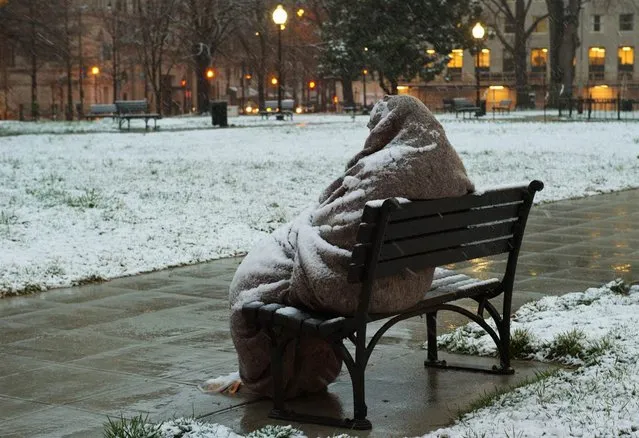 A homeless man sits coated in snow early on March 25, 2013 in Washington, D.C. A messy Monday was in store for millions along the East Coast, with winter weather advisories warning of a mixture of snow and rain for Washington, Philadelphia, metropolitan New York and parts of northeast New Jersey. (Photo by Karen Bleier/AFP Photo)