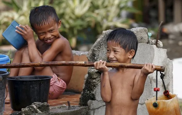 Children play as they take a bath outside their bunkhouse at a transitional shelter for Typhoon Haiyan survivors in Tacloban city in central Philippines November 2, 2015, ahead of the second anniversary of a devastating typhoon that killed more than 6000 people in central Philippines. (Photo by Erik De Castro/Reuters)