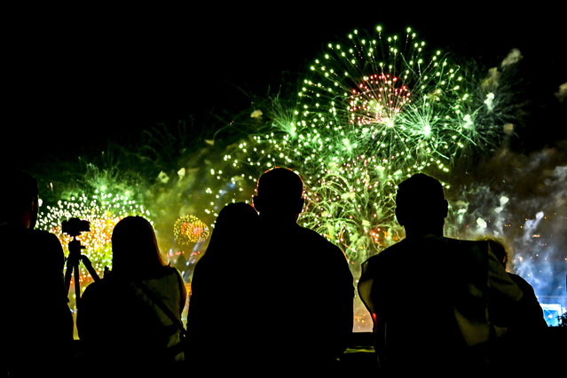 People watch as fireworks explode above River Danube as part of celebrations of the national holiday in Budapest, Hungary, Wednesday, August 20, 2025. (Phoot by Tibor Illyes/MTI via AP Photo)