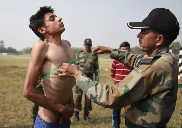 An Indian Army soldier takes chest measurement of a prospective candidate during a recruitment rally at Sunjwan Military station on the outskirts of Jammu, India, Friday, October 30, 2015. Thousands of young men from border areas attended the ten day recruitment rally Friday by the Indian Army for the aspirants that ends on November 10. (Photo by Channi Anand/AP Photo)