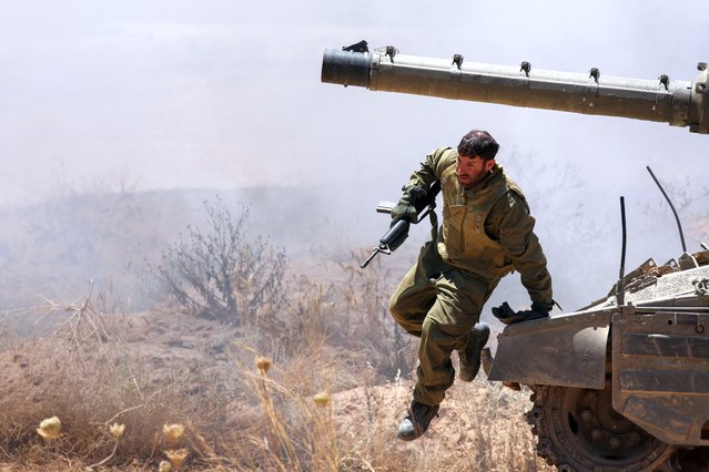 An Israeli soldier jumps off a tank, near the Israel-Gaza border, amid the ongoing conflict between Israel and the Palestinian Islamist group Hamas, in Israel, on May 16, 2024. (Photo by Shannon Stapleton/Reuters)\