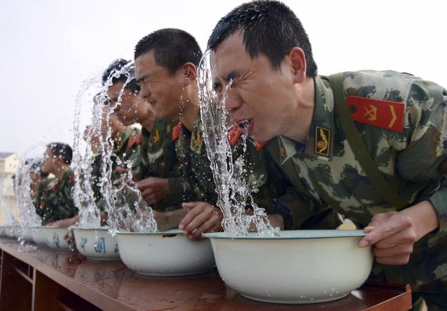 Paramilitary police snipers raise their heads from basins of water during a practice session of holding their breaths underwater, as part of a psychological training, at an annual drill in Nanjing, Jiangsu province, April 24, 2013. Picture taken April 24, 2013. (Photo by Reuters/China Daily)