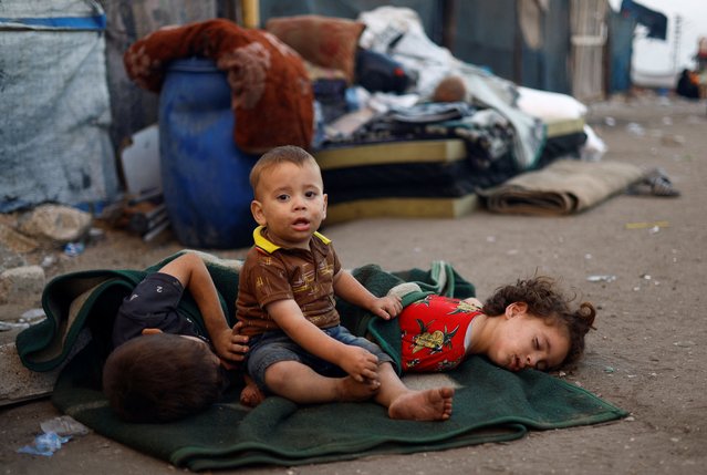 Children among displaced Palestinians fleeing northern Gaza due to an Israeli military operation rest on the way as they, along with others, move southward after Israeli forces ordered residents of Gaza City to evacuate to the south, in the central Gaza Strip, on September 19, 2025. (Photo by Mahmoud Issa/Reuters)