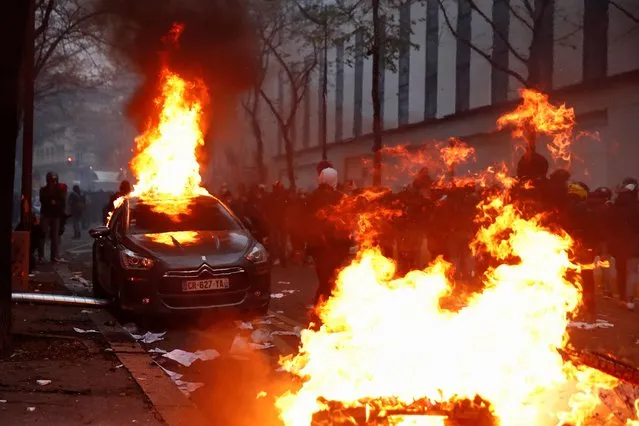 A car burns during a protest against the “Global Security Bill”, that right groups say would make it a crime to circulate an image of a police officer's face and would infringe journalists' freedom in the country, in Paris, France, December 5, 2020. (Photo by Gonzalo Fuentes/Reuters)