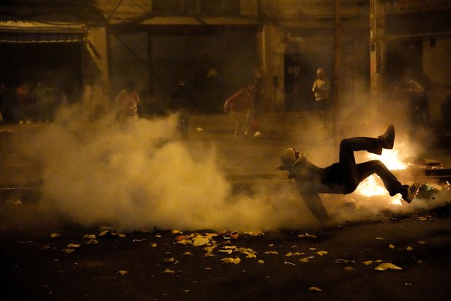 A demonstrator falls to the ground amidst the smoke during a protest against rising crime, economic insecurity, and corruption, a day after President Jose Jeri presented his cabinet, in Lima, Peru, on October 15, 2025. (Photo by Angela Ponce/Reuters)