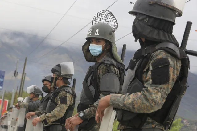 Guatemalan soldiers stands guard at a police checkpoint on the Motagua River to stop the advance of Honduran migrants in Zacapa, Guatemala, Tuesday, January 19, 2021. A once large caravan of Honduran migrants that pushed its way into Guatemala last week had dissipated by Tuesday in the face of Guatemalan security forces. (Photo by Oliver de Ros/AP Photo)